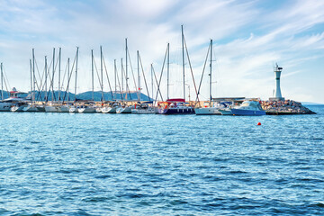 Luxury yachts and boats moored at the port marina and the lighthouse