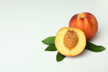 Ripe peach fruits with leaves on white background
