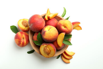 Wooden bowl with peach fruits on white background