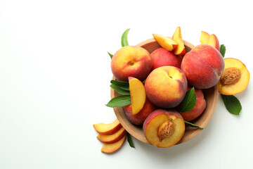 Naklejka na ściany i meble Wooden bowl with peach fruits on white background