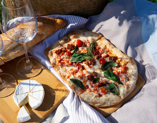 picnic in nature: pizza, cheese, baguette and glasses of wine