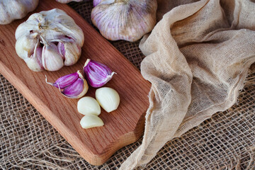 Cloves and heads of garlic on a wooden board, rustic style, natural eco product