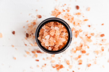Fototapeta na wymiar Himalayan Pink Rock Salt. Mineral-rich salt from the Himalayan region. in glass jar on wite background. Top view