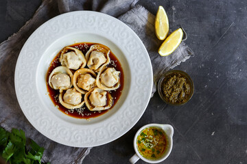 Appetizing meat dumplings. Dumplings in a white plate with soy sauce and sesame seeds. Top view. Copy space.