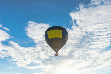 Hot Air Balloon and blue sky white cloud.Blue yellow hot air balloon in the air at summer evening.
