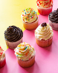 variety of cupcakes with cream and sprinkles