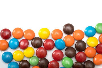 Variety of colorful candies coated on white background