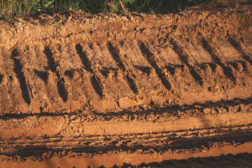 truck or heavy bulldoser or excavator caterpillar prints in sand in gravel quarry road.