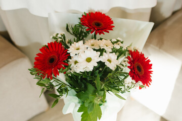 A bouquet of beautiful red gerberas and white chrysanthemums in a vase
