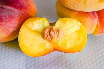 Fresh flat peach fruits on plate, cut close-up