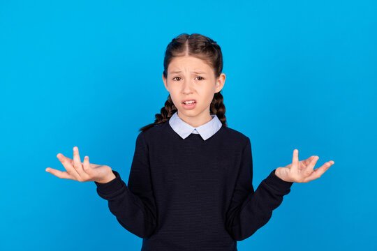 Photo of young preteen girl unhappy negative clueless questioned no answer think isolated over blue color background