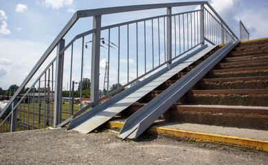 The staircase of the pedestrian crossing with traces of destruction. Two wheelchair rails. Metal...
