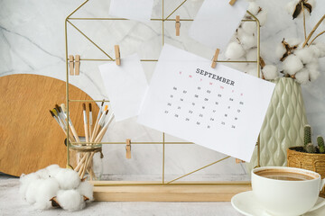 SEPTEMBER CALENDAR cards and posters mock ups on grid board. Copy space. Home office desktop. Freelance bloggers workplace. Brushes and palette