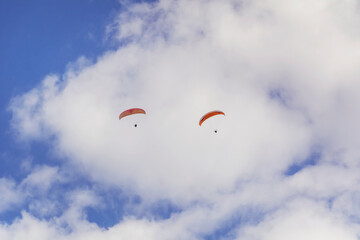 Paragliders Flying  in the Blue Cloudy Sky