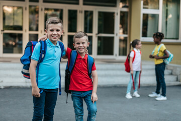 Schoolchildren standing and talking in school yard.