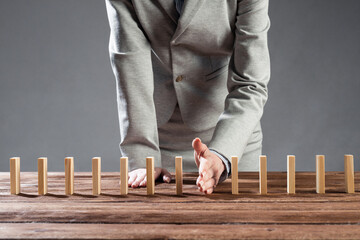 Business woman hand stop domino effect