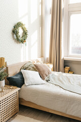 A bed with pillows and Christmas decorations in the bedroom in a Scandinavian style. Interior of the house