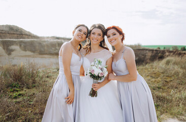 Fototapeta na wymiar Pretty bride with her friends walking in the sandy mountains.