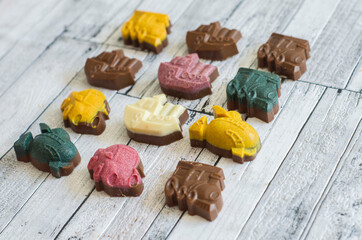 Mini handmade colored chocolates from kerob in the form of a locomotive, car, grasshopper. ship.