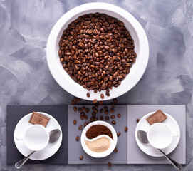 Coffee beans in plate and empty cup on abstract painted background texture. Cup of coffee