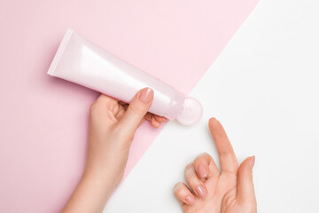 Cosmetic face mask on a light background, female hands squeeze the contents onto the finger.