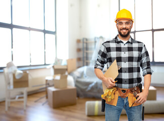 repair, construction and building concept - happy smiling male worker or builder in helmet with clipboard over home room background