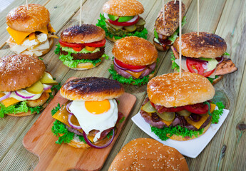 View of assorted appetizing hamburgers on wooden table. High quality photo
