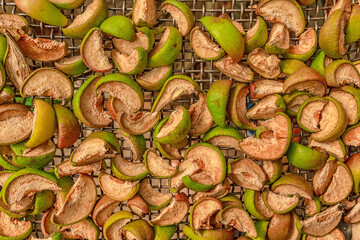 Apple and pear slices are dried on a grid. Production of dried fruits, harvesting.