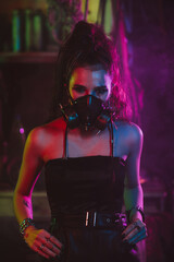Fototapeta na wymiar Cyberpunk cosplay. A girl in a gas mask in a post-apocalyptic style with neon lighting