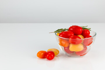 Colored cherry tomatoes in a glass bowl
