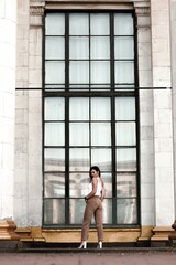 street style shot of a girl. photo of a young girl on the background of the building, columns.