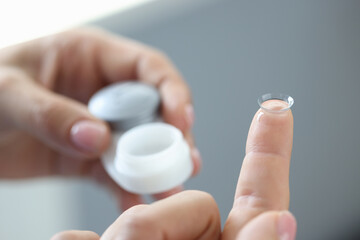 New clear contact lens on finger closeup