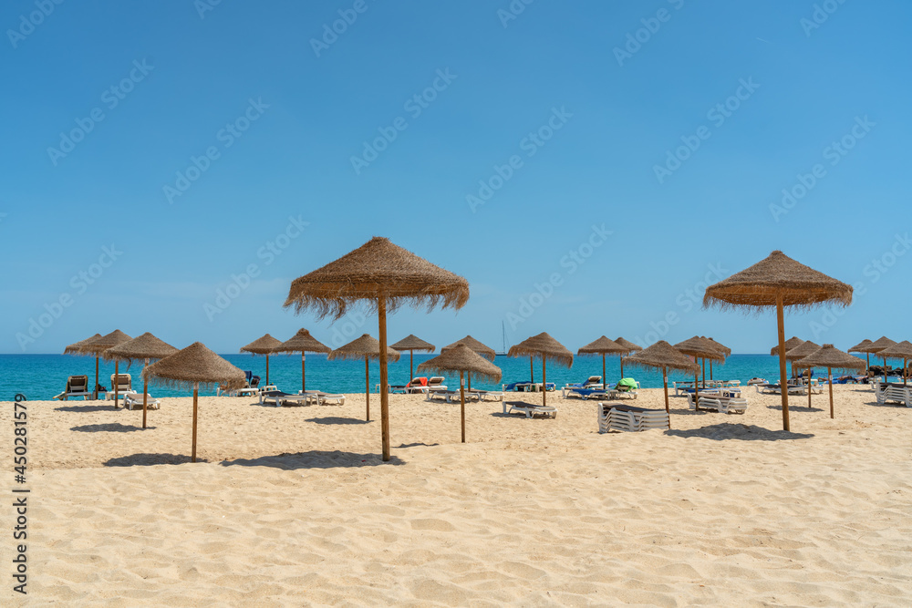 Wall mural View of the luxury beach on the sea with sun loungers and umbrellas, in the tourist zone of the tropics.