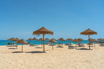 View of the luxury beach on the sea with sun loungers and umbrellas, in the tourist zone of the tropics.