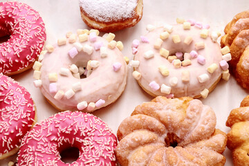 Various types of donuts on pink background.