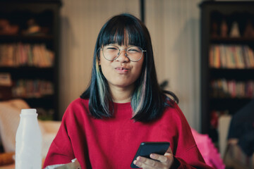 happiness face of asian teenager eating snack in home living room