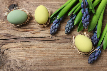 Violet hyacinth flowers and Easter eggs on wooden background.
