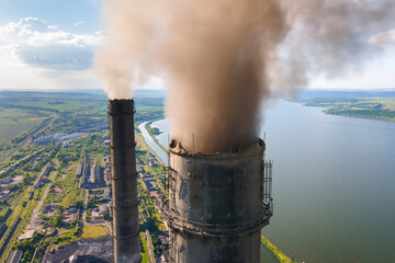 Aerial view of coal power plant high pipes with black smokestack polluting atmosphere. Electricity...