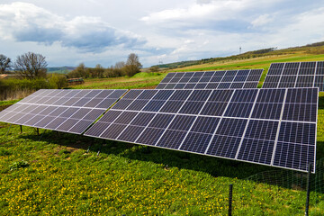 Aerial view of blue photovoltaic solar panels mounted on backyard ground for producing clean...
