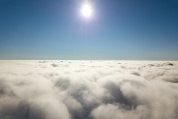 Fototapeta na wymiar Aerial view from above of white puffy clouds in bright sunny day.