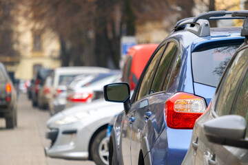 Cars parked in a row on a city street side.
