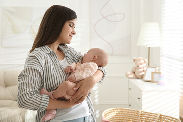 Mother holding her sleeping baby at home