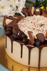 cake decorated with milk chocolate cubes and berries. close-up