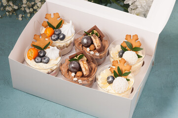 a set of desserts in plastic cups decorated with chocolate and fruit