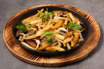 fried potatoes with wild mushrooms in a frying pan