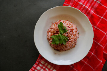 red rice, Red steamed rice or nasi merah served in plate isolated on black background