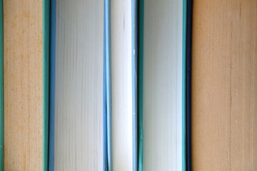 Stack of books with blue and green covers. Selective focus.