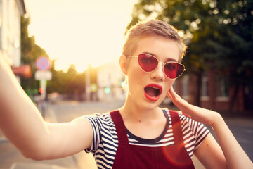 fashionable woman wearing sunglasses outdoors walking close-up