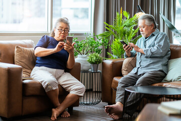 happiness asian retired couple enjoy playing and competition game smartphone mobile online together...