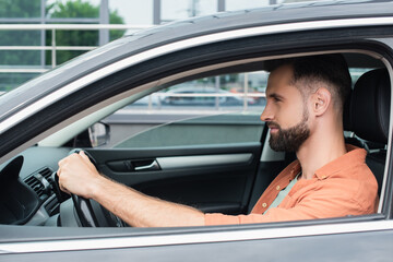 Side view of bearded man driving car